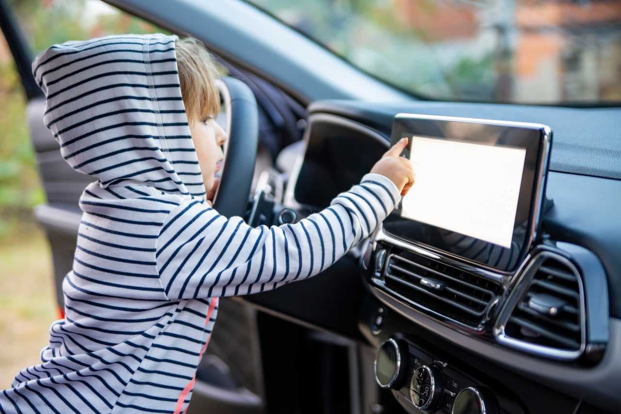 Barn pekar på infotainmentsystem i en bil