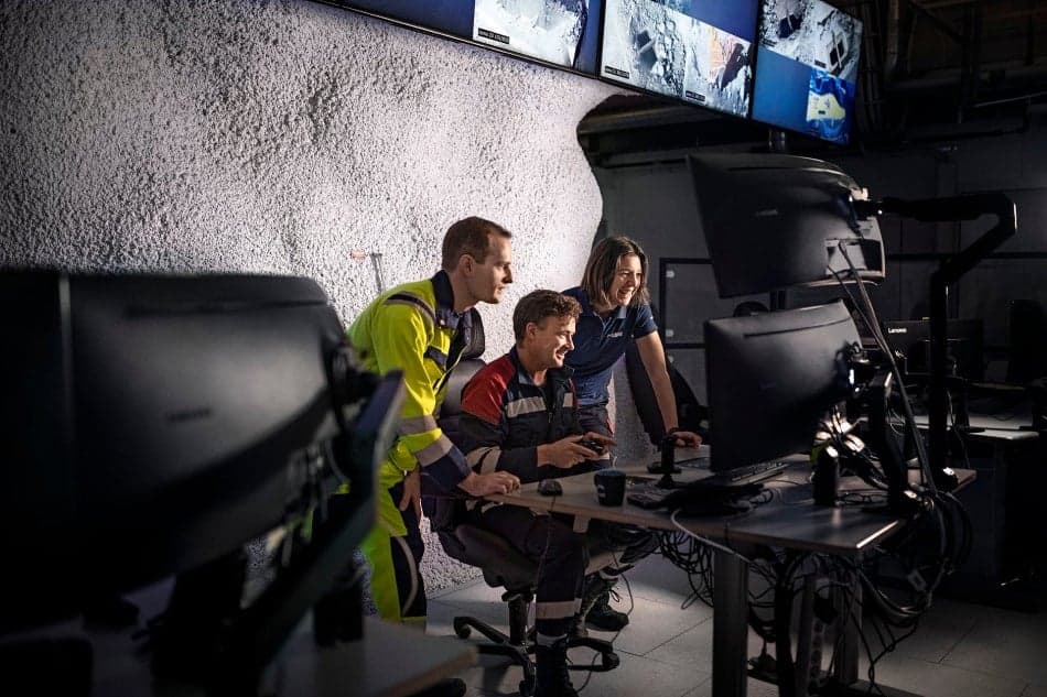 Personer i en gruva tittar på en dator